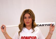 a woman in a baseball uniform holding a bat