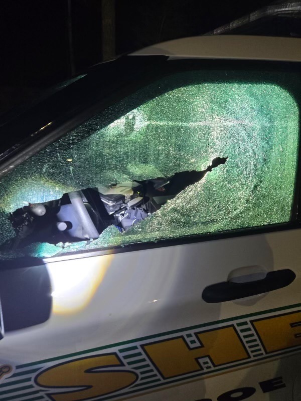 a police car with a broken windshield at night