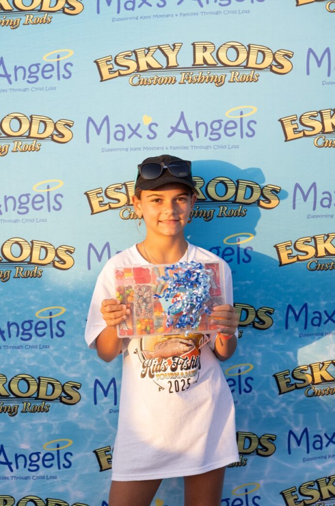 a boy in a white shirt and black hat holding a book