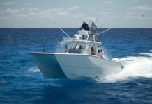 a white boat with people on it in the ocean