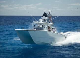 a white boat with people on it in the ocean