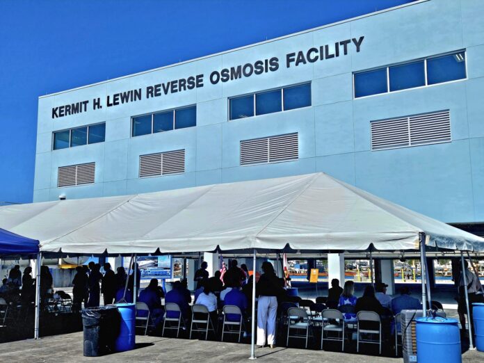 reverse osmosis plant Large a group of people standing outside of a building