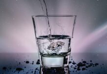 a glass filled with water with a sky background