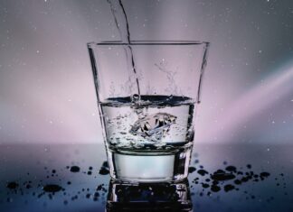 a glass filled with water with a sky background