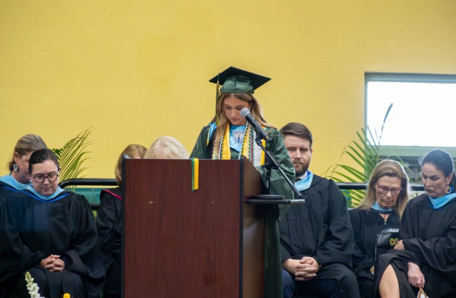 a woman standing at a podium in front of a group of people