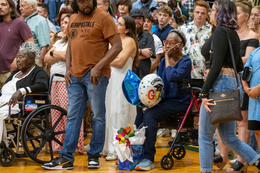a crowd of people watching a man in a wheel chair