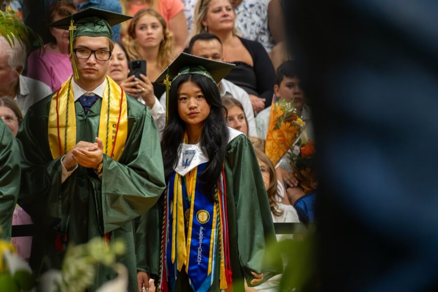 a group of graduates walking through a crowd