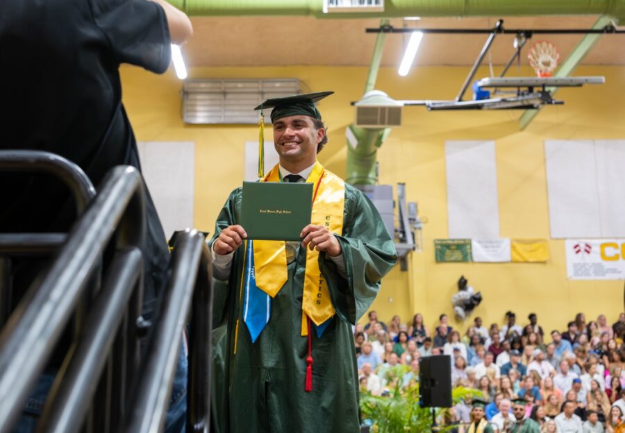 a man in a graduation gown holding a diploma
