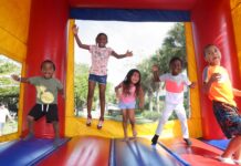 a group of children jumping on a bouncy house
