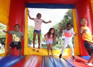 a group of children jumping on a bouncy house