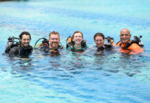 a group of people in the water with scuba gear