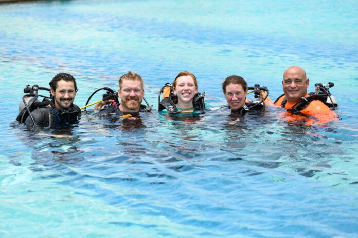 a group of people in the water with scuba gear