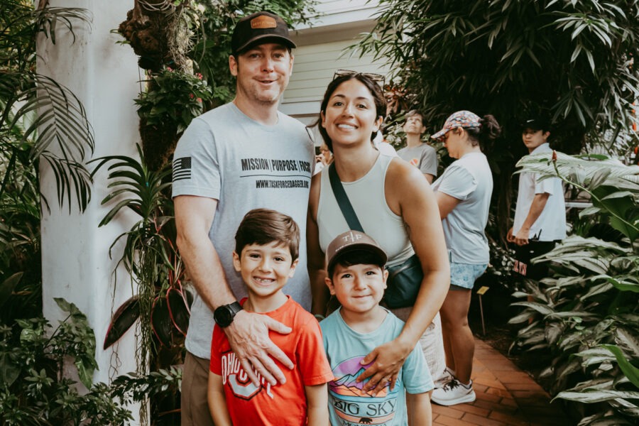 a family poses for a picture in a greenhouse