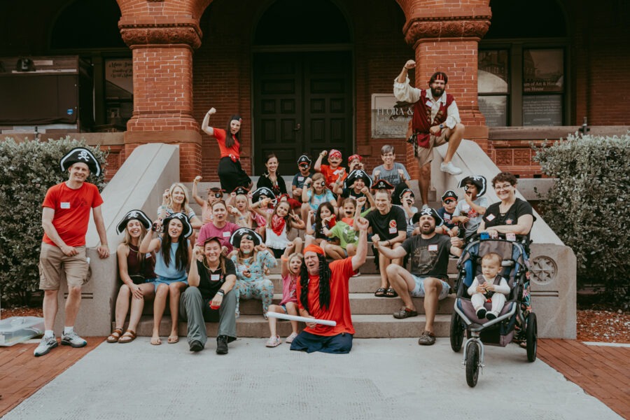 a group of people posing for a picture in front of a building