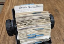 a stack of mail sitting on top of a wooden table