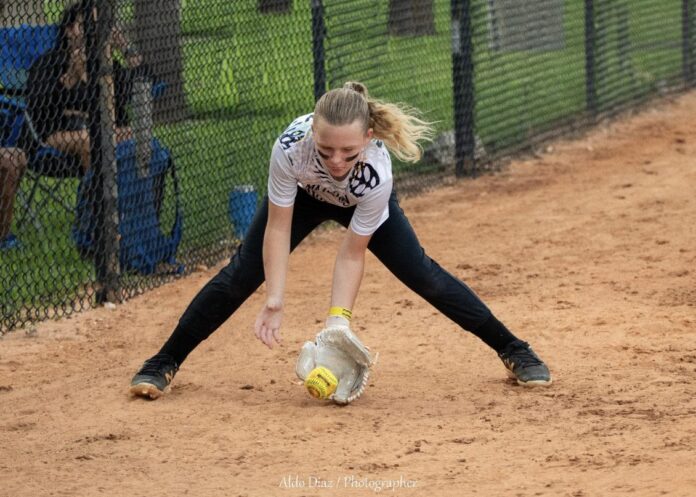 3. Elle Mowry a woman reaching for a ball on a baseball field