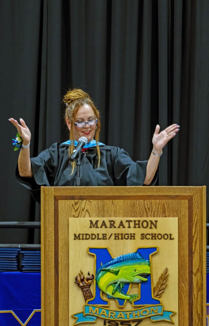 a woman standing at a podium in front of a microphone