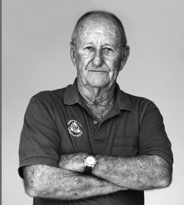 a black and white photo of a man with his arms crossed