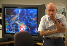 a man standing in front of a computer monitor