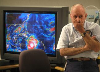 a man standing in front of a computer monitor