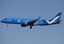 a blue and white airplane flying in the sky