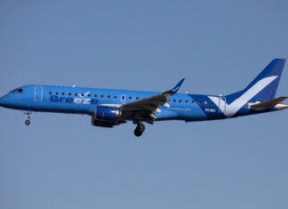 a blue and white airplane flying in the sky