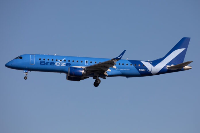 Breeze Airways plane a blue and white airplane flying in the sky