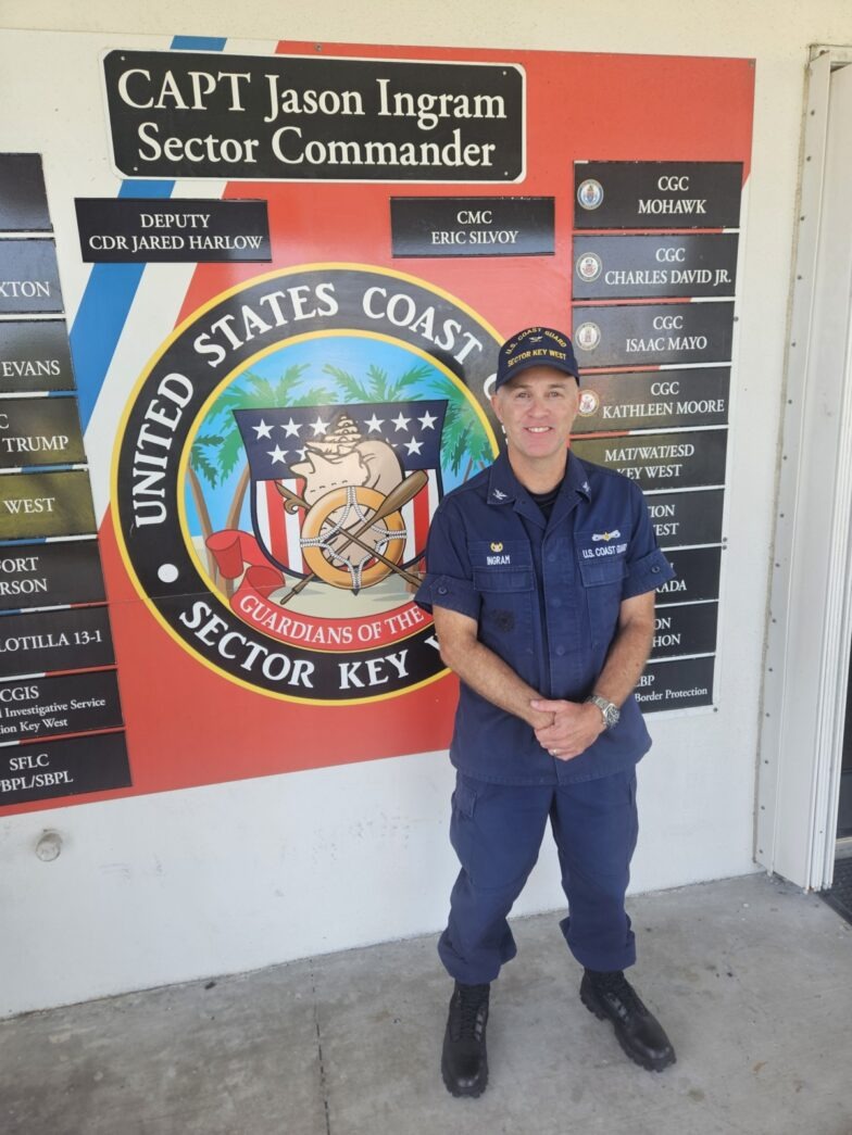 a man in uniform standing in front of a sign