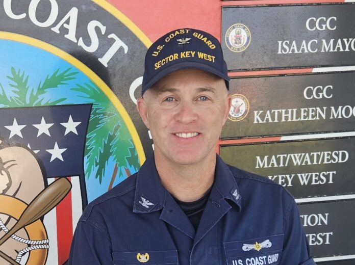 a man in uniform standing in front of a sign
