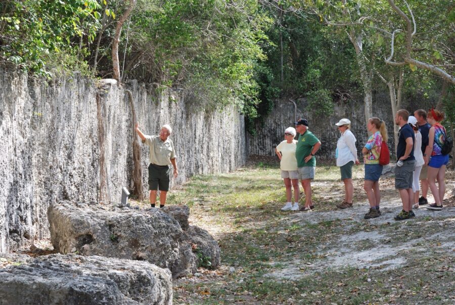 a group of people standing next to a stone wall
