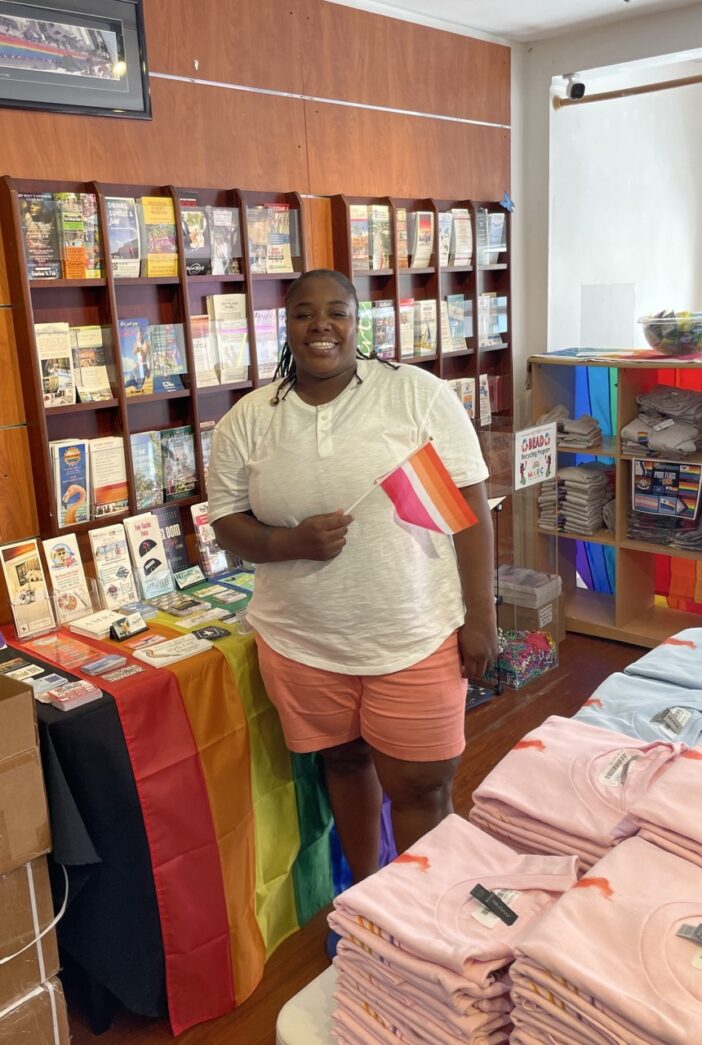 a woman standing in front of a display of t - shirts