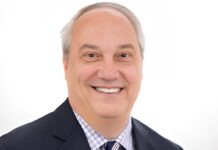 a man in a suit and tie smiling at the camera