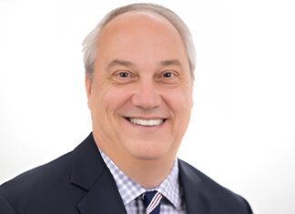 a man in a suit and tie smiling at the camera