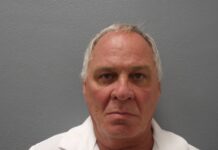 a man in a white shirt is looking at the camera