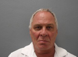 a man in a white shirt is looking at the camera