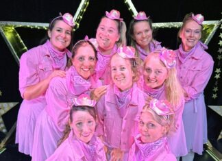 a group of women in pink outfits posing for a picture