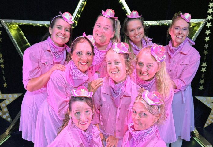 IMG_2935 a group of women in pink outfits posing for a picture
