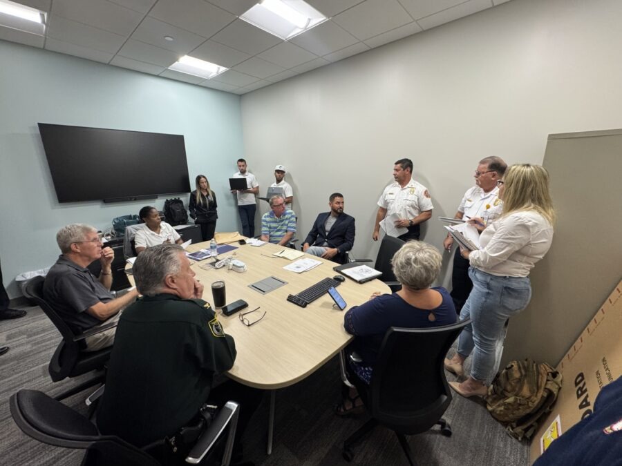 a group of people standing around a conference table