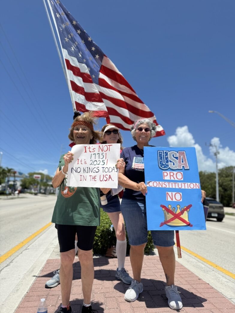 a group of people holding signs on the side of a road