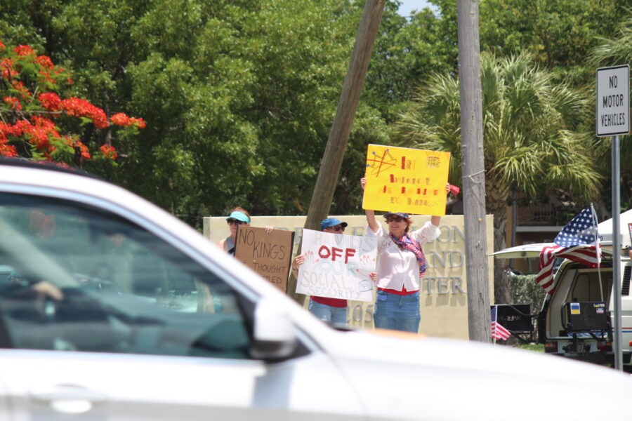 a group of people holding signs on the side of a road
