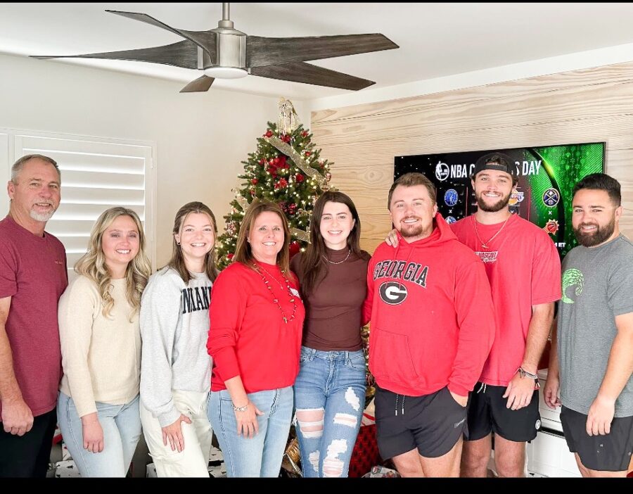 a group of people standing in front of a christmas tree