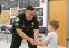 a police officer handing a boy a turtle