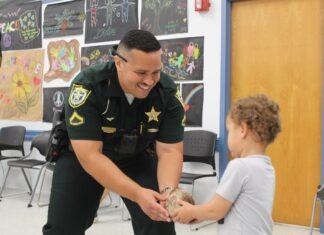 a police officer handing a boy a turtle