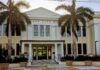 a large white building with palm trees in front of it