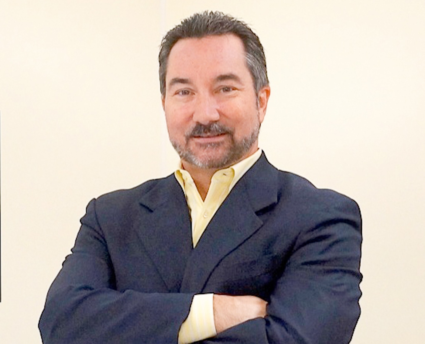 a man in a suit standing with his arms crossed