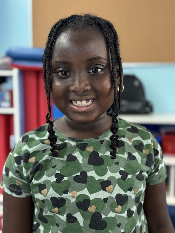a young girl with braids smiling at the camera