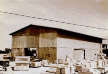 a black and white photo of a building with boxes in front of it