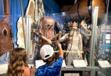 a boy and girl looking at a display of costumes