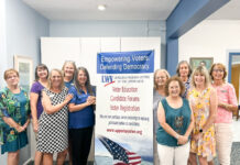 a group of women standing next to a sign
