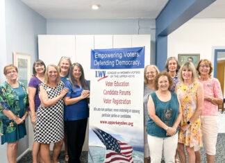 a group of women standing next to a sign